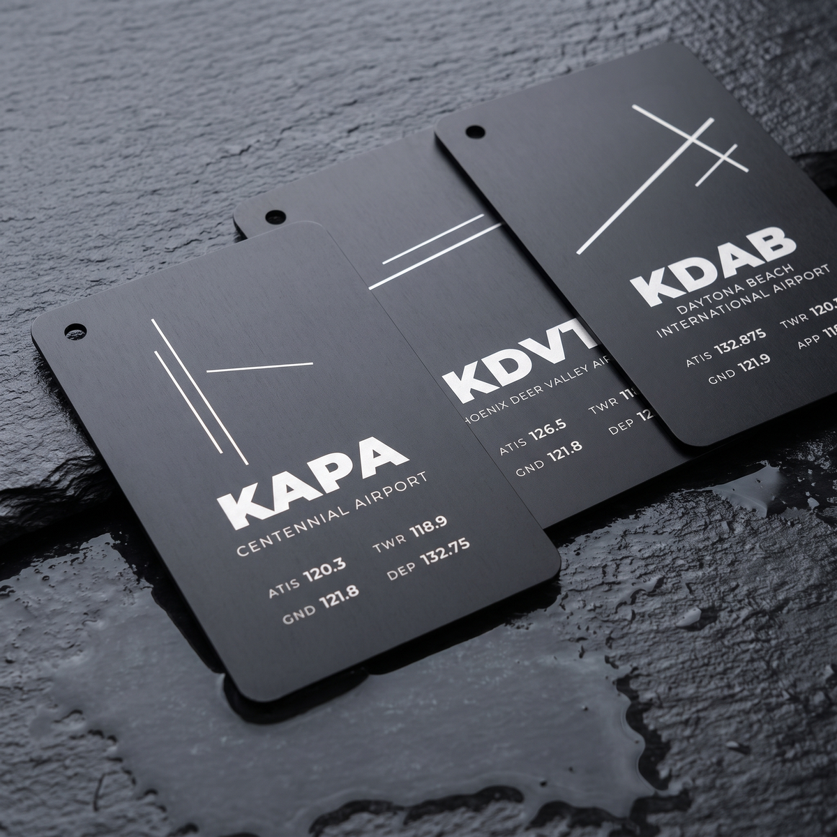 three engraved airport layout cards on wet slate